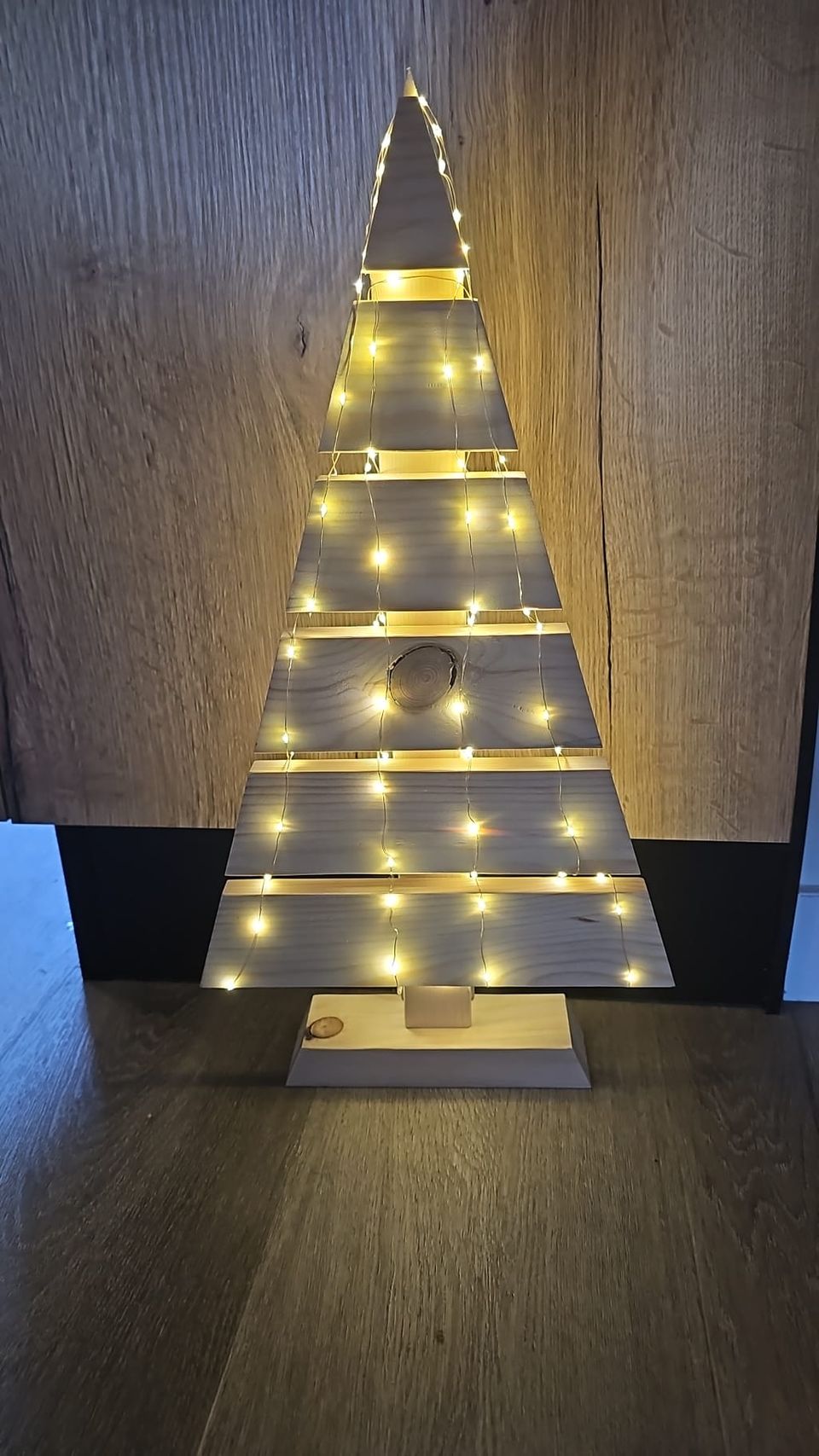 Kerstboom van houten planken met lichtjes